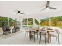 Bright dining area featuring a modern table setting, stylish chairs, and scenic views of the outdoor pool and backyard at 1886 San Mateo Dr, Dunedin, FL 34698