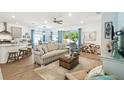 Open-concept living room with a comfortable sofa, a ceiling fan, and natural light from the adjacent dining area at 19629 Fort King Run, Brooksville, FL 34601