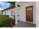 Close-up of a charming front door with a decorative window and manicured landscaping at 1979 E Skyline Dr, Clearwater, FL 33763