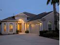 Beautiful single-story home with great lighting and well-maintained landscaping at dusk at 20903 Amanda Oak Ct, Land O Lakes, FL 34638