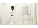 Bright, all-white bathroom showcasing a shower, toilet, and vanity with a neutral-toned mirror and minimalist decor at 22075 Storybook Cabin Way, Land O Lakes, FL 34637
