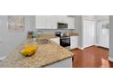 Well-lit kitchen showcasing granite countertops, stainless appliances and wood flooring at 3002 E 24Th Ave, Tampa, FL 33605