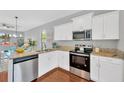 Modern kitchen features stainless steel appliances, granite countertops, and ample white cabinetry at 3002 E 24Th Ave, Tampa, FL 33605