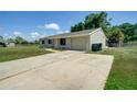 Single-story home with a driveway, attached garage, and green lawn on a sunny day at 3262 Montclair Cir, North Port, FL 34287