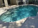 Sparkling pool with tiled edges and concrete surround, partially enclosed by a screened lanai at 3586 Culpepper Ter, North Port, FL 34286