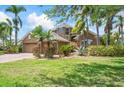 Beautiful home with mature trees, green grass, and a three car garage with a paver driveway at 4111 70Th E Ave, Ellenton, FL 34222