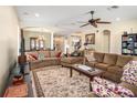 Spacious living room with elegant furnishings, ceiling fan, and seamless flow into the dining area at 4206 Morning Breeze Ct, Tampa, FL 33619