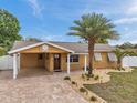 Charming single Gathering home features a brick driveway, covered front porch, and well-manicured landscaping at 4815 Plantation Dr, Tampa, FL 33615