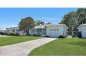 Inviting single-story home with a green lawn and a paved driveway leading to the garage at 5000 18Th S Ave, Gulfport, FL 33707