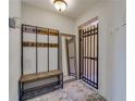 Inviting entryway with stone flooring, a coat rack with a bench and an decorative wrought iron security gate at 5033 Blue Runner Ct, New Port Richey, FL 34652