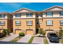 Charming multi-level condo exterior featuring a brick driveway, tan walls, dark shutters and attached garages at 5033 Blue Runner Ct, New Port Richey, FL 34652