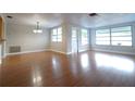 Bright living room featuring hardwood floors, fresh paint and abundant natural light at 6800 William Tell Dr, New Port Richey, FL 34653