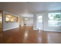 Open-concept living room with hardwood floors, ample natural light, and neutral paint at 6800 William Tell Dr, New Port Richey, FL 34653
