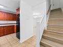Bright entryway with staircase, tile flooring, and access to kitchen and living room at 7535 Abonado Rd, Tampa, FL 33615