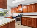 Well-equipped kitchen featuring wood cabinetry and stainless steel appliances at 7535 Abonado Rd, Tampa, FL 33615