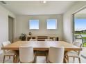 Well-lit dining room with large table and chairs next to sliding glass door to backyard at 8960 Windlass Cv, Parrish, FL 34219
