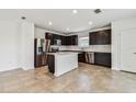Modern kitchen featuring stainless steel appliances, dark cabinetry, and a bright white kitchen island at 10520 Hidden Banks Gln, Parrish, FL 34219