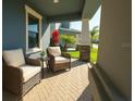 Cozy front porch seating area featuring wicker chairs and a small table, offering a relaxing outdoor space at 10628 Bahama Woodstar Ct, Riverview, FL 33579