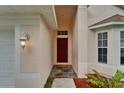 Close-up view of home entryway, with a covered porch, stylish door, and manicured landscaping at 11626 Pure Pebble Dr, Riverview, FL 33569