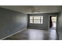 Open living room featuring wood floors, a ceiling fan, and natural light at 12041 Environmental Dr # 6, New Port Richey, FL 34654