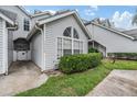 Townhome featuring light gray facade, well-manicured landscaping, and a private walkway for easy access at 12233 Armenia Gables Cir # 12233, Tampa, FL 33612