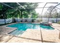 A screened-in pool and spa is surrounded by pavers and landscaping at 1510 Rushgrove Cir, Dover, FL 33527
