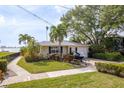 Charming single-story home featuring a lush landscaped front yard, a single car garage and boat trailer at 1748 Sunset Dr, Clearwater, FL 33755