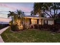 Well-lit exterior showcases a charming single-story home with lush landscaping and nighttime appeal at 1748 Sunset Dr, Clearwater, FL 33755