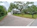 Elegant home featuring a brick driveway leading to a well-maintained two-story house with a spacious front yard at 2305 S Hesperides St, Tampa, FL 33629