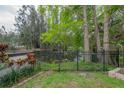 Backyard view featuring a serene pond and wrought iron fence, surrounded by lush greenery at 2305 S Hesperides St, Tampa, FL 33629