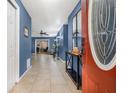 Bright entryway with blue walls, tile floors, and a decorative mirror table that enhances the foyer's appeal at 2316 Merrily N Cir, Seffner, FL 33584
