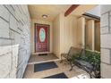 Inviting front porch with stylish stone accents, a cozy bench, and an oval-glass front door at 2316 Merrily N Cir, Seffner, FL 33584