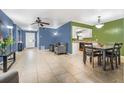 Open-concept living room with tile floors and a view of dining area adjacent to the open-concept kitchen at 2316 Merrily N Cir, Seffner, FL 33584