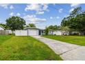 Charming single-story home features a lush front yard, long driveway, and attached garage at 2401 Havana Dr, Clearwater, FL 33764
