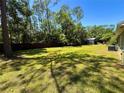 Expansive backyard featuring a lush lawn, a wooden fence, and mature trees for added privacy at 4310 Lithia Pinecrest Rd, Valrico, FL 33596