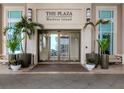 Exterior view of the building's entrance, showcasing glass doors, planters, and signage for The Plaza Harbour Island at 450 Knights Run Ave # 414, Tampa, FL 33602