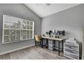 Well-lit home office with a vaulted ceiling, features a large window and neutral, modern decor at 4921 Barnstead Dr, Riverview, FL 33578