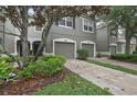 Charming townhome showcasing a two-car garage, meticulously landscaped yard, and inviting facade at 4921 Barnstead Dr, Riverview, FL 33578