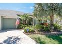 Lovely home showcasing colorful landscaping, an American flag, and an ADT security sign at 5269 Karlsburg Pl, Palm Harbor, FL 34685
