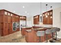 A spacious kitchen with custom wood cabinets, stone floors, double oven and a large center island with bar seating at 5807 Thoreau Pl, Lithia, FL 33547