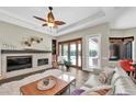 A living room with a decorative fireplace, and plush seating that leads to the outdoor pool area through french doors at 5807 Thoreau Pl, Lithia, FL 33547
