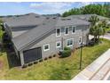 Aerial view of home with a screen patio, manicured lawn, and a blend of modern architecture at 5833 Grand Sonata Ave, Lutz, FL 33558