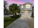Charming two-story home with a well-maintained lawn and a long driveway leading to the garage at 5833 Grand Sonata Ave, Lutz, FL 33558