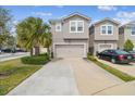 Two story home with a two car garage, palm tree, and beautiful landscaping at 5833 Grand Sonata Ave, Lutz, FL 33558