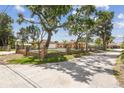 Charming, single-story home featuring a brick fence, mature trees, and a well-manicured front lawn on a bright, sunny day at 6732 Udell Ln, Hudson, FL 34667