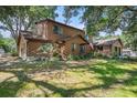 Beautiful log cabin home featuring lush green lawns and mature trees at 7157 Quail Hollow Blvd, Wesley Chapel, FL 33544