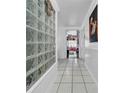 Bright hallway with white tile flooring, white walls, and glass block detail at 8115 N Ola Ave, Tampa, FL 33604