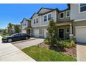 Well-maintained townhome showing brick driveway, manicured lawn, private garage, and inviting entrance at 8953 Gallantree Pl, Land O Lakes, FL 34637