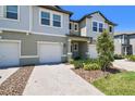 Charming townhome featuring a manicured lawn, private garages, and a welcoming entrance at 8953 Gallantree Pl, Land O Lakes, FL 34637