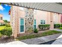 Condo exterior showcasing stone accent wall, manicured bushes, and covered parking at 101 Dogwood Cir, Seminole, FL 33777